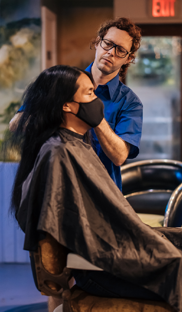 Hair stylist cutting long hair