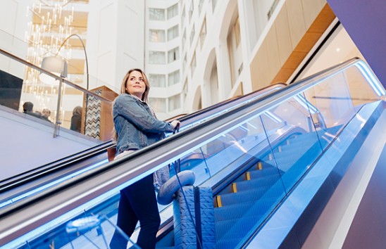 Lindsey going up an elevator on a work trip, which she will be reimbursed for through Direct Deposit.